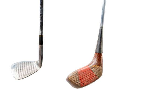 Vintage iron and wooden golf club heads displayed on a clean white background.