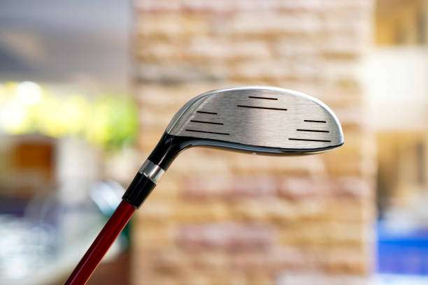 Close-up of a metal golf club head on a red shaft.