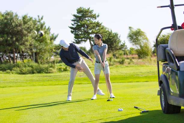 Couple practicing golf swing with golf clubs on a sunny day.
